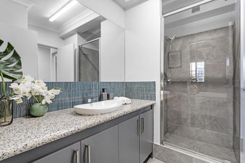 a bathroom with a sink and a shower at City Living Retreat - 2BR Apartment in East Perth in Perth