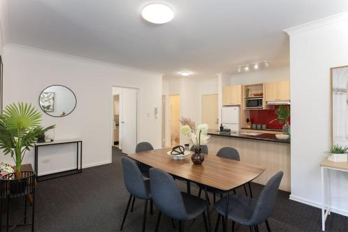 a dining room and kitchen with a table and chairs at Spacious 2 Bedroom Pool & Gym PerthCBD,Optus,WACA in Perth