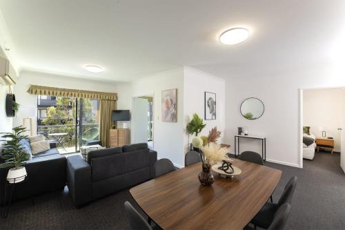 a living room with a table and a couch at Spacious 2 Bedroom Pool & Gym PerthCBD,Optus,WACA in Perth