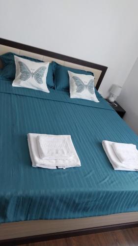 a bed with blue sheets and white towels on it at Ianca Urban Stay in Şelimbăr