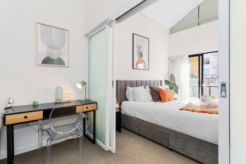 a bedroom with a desk and a bed and a desk and chair at The CBD Gateway Modern 1BR Suite near UWA & Park in Perth