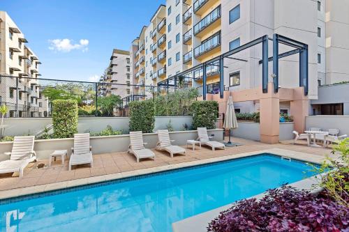 an image of a swimming pool with chairs and a building at The CBD Gateway Modern 1BR Suite near UWA & Park in Perth