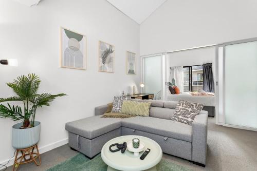 a living room with a couch and a table at The CBD Gateway Modern 1BR Suite near UWA & Park in Perth