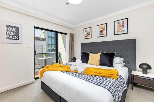 una camera da letto con un grande letto con una coperta gialla di Stylish City 1bdrm Apt Perth Heart 2 mins river a Perth