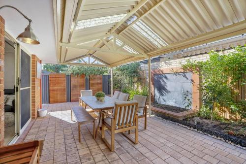 a patio with a table and chairs and a roof at Rivervale Family Retreat Quiet 3BR Home Near Swan in Perth
