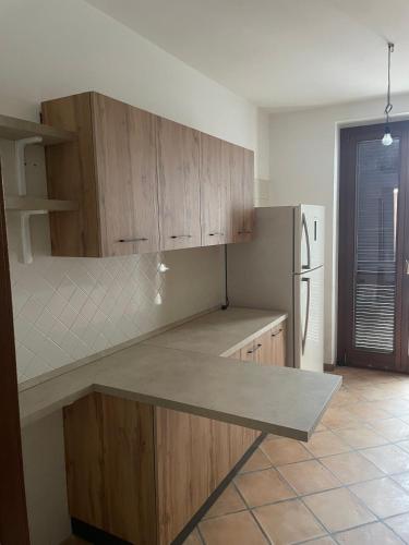 a kitchen with wooden cabinets and a refrigerator at DD's -Guest House- in Taviano