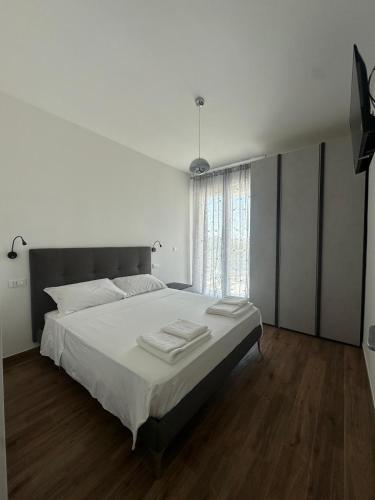 a white bedroom with a large bed with white sheets at Bari San Francesco Mare in Bari