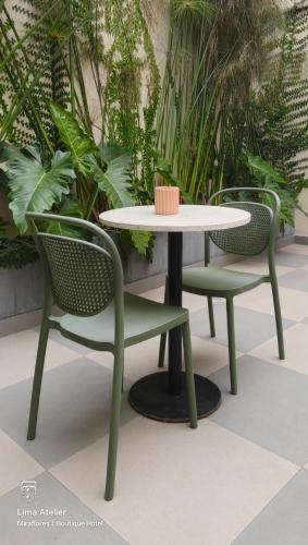 two chairs and a table and a table and chairs at Lima Atelier Boutique in Lima