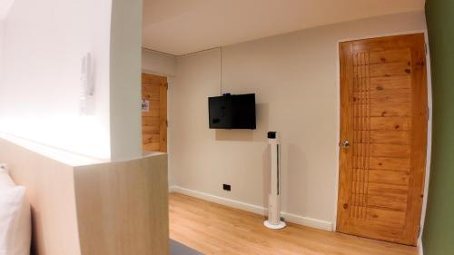 a room with a tv on the wall and a door at V1 boutique hotel in Kanchanaburi