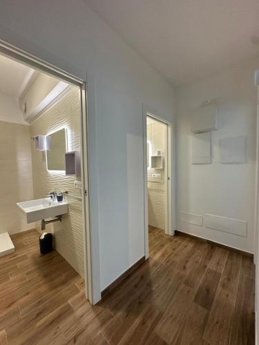 a white bathroom with a sink and a mirror at Bari San Francesco Mare in Bari