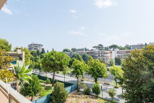 - une vue sur une rue bordée d'arbres et de bâtiments dans l'établissement Flat with swimming pool close to the sea, à Cagnes-sur-Mer
