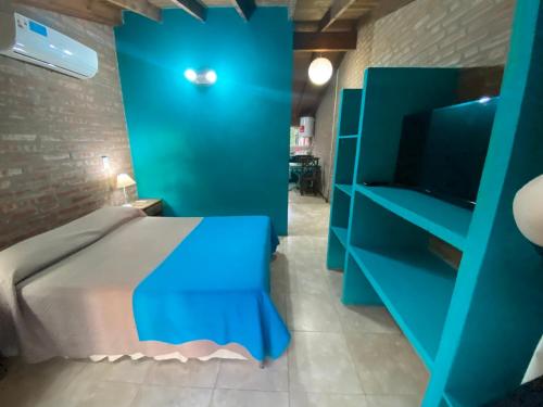 a blue bedroom with a bed and a blue cabinet at Cabañas Burung Hantu in Merlo