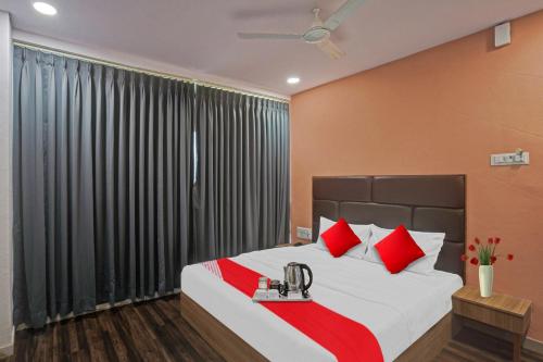 Un dormitorio con una cama grande con almohadas rojas. en Hotel O Infinity, en Surat