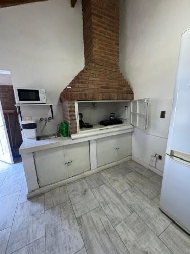 a kitchen with a stove and a brick fireplace at Cabañas Burung Hantu in Merlo