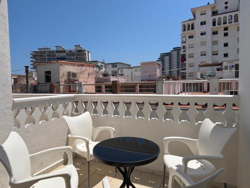 a patio with chairs and a table on a roof at VMC Rooms in Tavernes de Valldigna