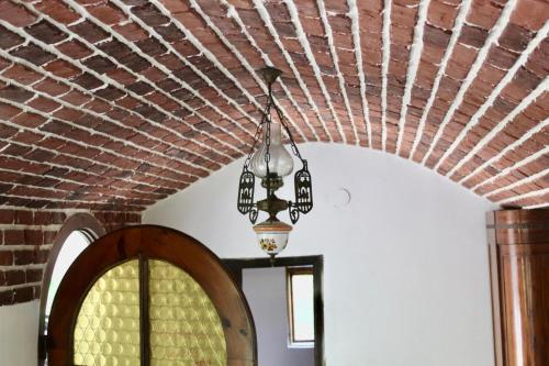 a brick ceiling with a chandelier hanging from it at Conăcel între Vulcani 