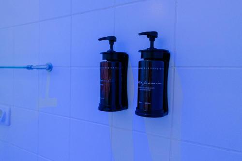 two black bottles are hanging on a wall at Camaçari Plaza Hotel in Camaçari