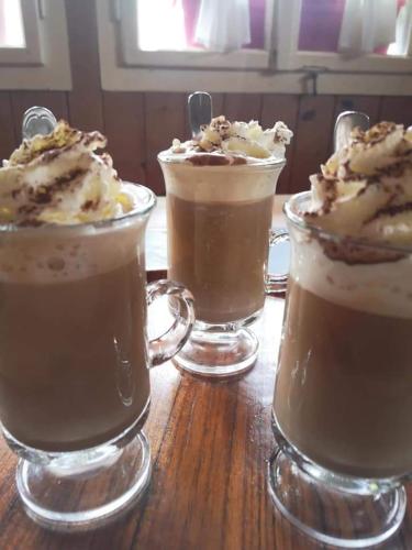 three desserts in glass cups on a wooden table at Doppelbett im Schlafraum einer Alphütte in Bisisthal