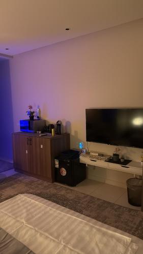 a living room with a large flat screen tv on a wall at استديو أنيق ومجهز بعناية ليوفر لك اقامة مريحة وهادئة 01 in Al Khobar