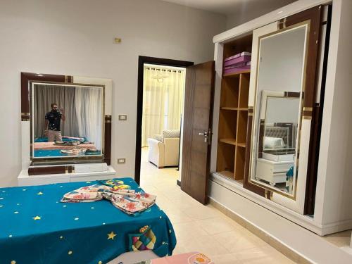 a man taking a picture of a bedroom with a mirror at فرصة نادرة فيلا مستقلة بحمام سباحة خاص in El Alamein