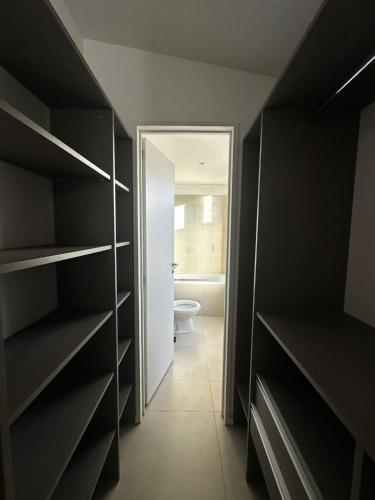 a bathroom with black shelves and a toilet at Pacifico Departamentos in Ushuaia