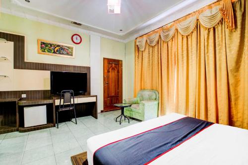 a bedroom with a bed and a flat screen tv at Dancenter S Hotel in Tanjunguma