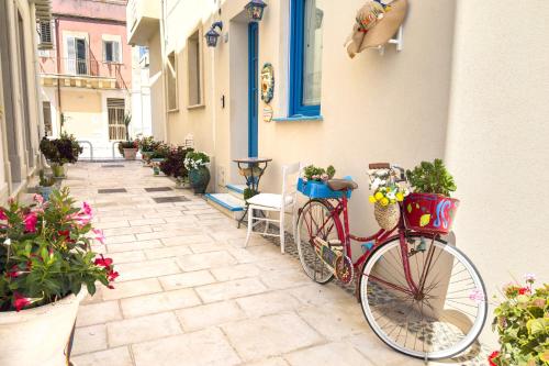 a red bike parked next to a building with flowers at Tumy's Room in Marzamemi