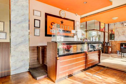 a bar in a restaurant with a clock on the wall at Dancenter S Hotel in Tanjunguma