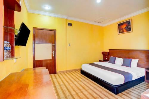 a hotel room with a bed and a television at Dancenter S Hotel in Tanjunguma