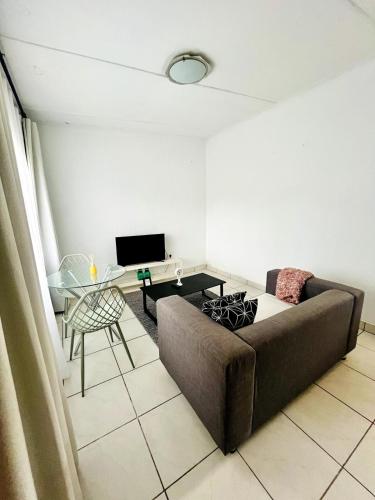 a living room with a couch and a table at Central Maseru - 2 Bedroom Apartment in Maseru