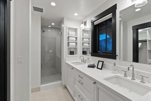 a white bathroom with two sinks and a shower at 430 Cresta in Edwards