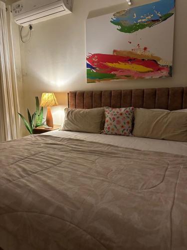 a bed in a bedroom with a painting on the wall at The Jungle Retreat by Jabula Getaways in Dehradun