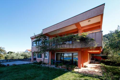 a house with an orange facade and a yard at Apartman Lavanda in Kali