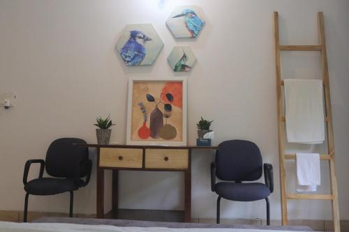 a room with two chairs and a desk with a painting at The Jungle Retreat by Jabula Getaways in Dehradun