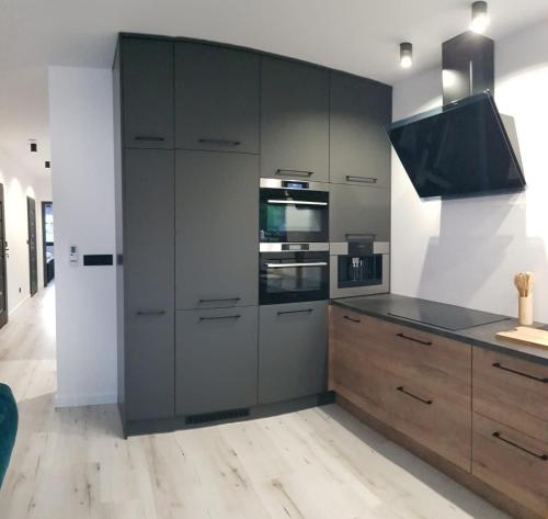a kitchen with stainless steel appliances and wooden cabinets at Business & Relax House in Jejkowice