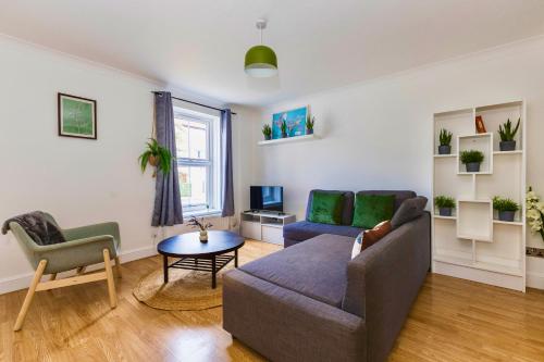 a living room with a couch and a table at Wimbledon 3 Bed - Free Van Parking - Sleeps 7 - Contractors in Mitcham