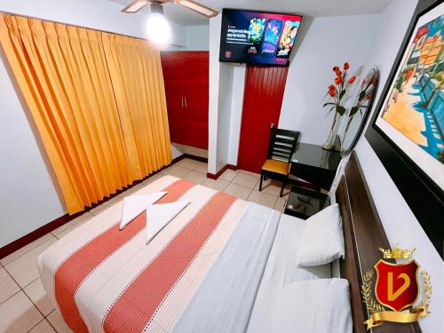 a hotel room with a bed and a tv at Veneccia Gold Hotel in Chiclayo