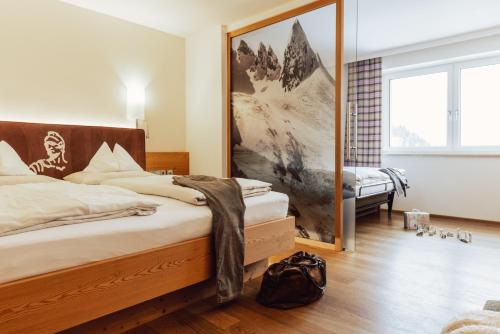 a bedroom with a bed and a large mirror at Hotel Römerhof Superior in Obertauern