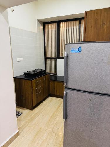 a kitchen with a refrigerator in a room at LUXE Premium Service Appartment in Mysore