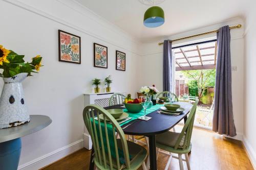 a dining room with a table and chairs and a window at Wimbledon 3 Bed - Free Van Parking - Sleeps 7 - Contractors in Mitcham