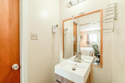 a bathroom with a sink and a mirror at American Inn by OYO Colorado City I-20 in Colorado City