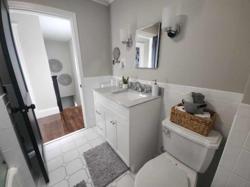 a bathroom with a toilet and a sink and a mirror at The Fairview in Peabody