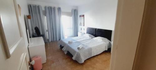 a bedroom with a bed in a white room at La Maison dos Prazeres in Portimão