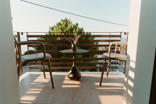 a balcony with two chairs and a table and a tree at Ollenia's Harmony Luxury Apartments in Derveni
