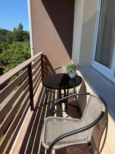 a table and two chairs on a balcony at Cozy Seaside apartments in Carnikava