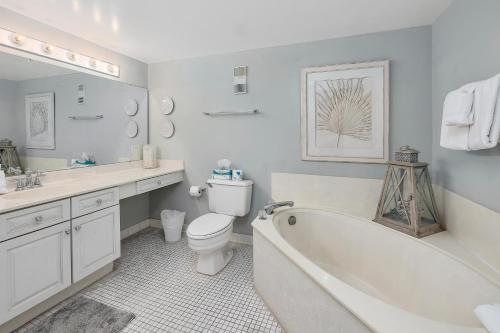 une salle de bains avec baignoire, toilettes et lavabo dans l'établissement Beach Club #308, à Île de Saint-Simon