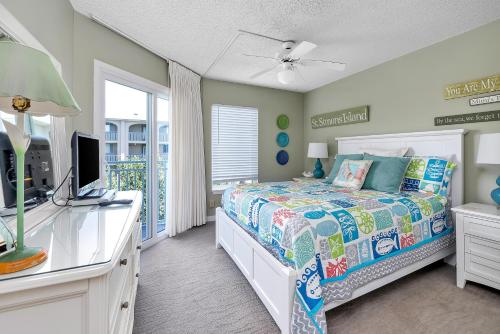 une chambre avec un lit et une télévision dans l'établissement Beach Club #308, à Île de Saint-Simon