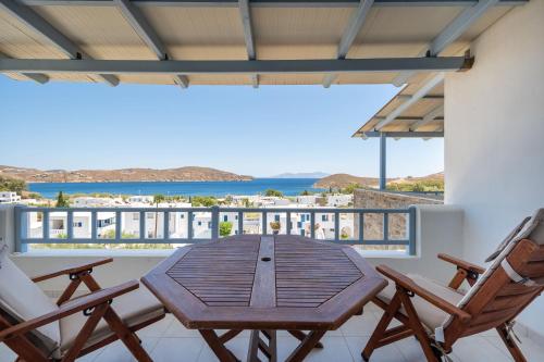 a balcony with a wooden table and two chairs at Medusa Accommodation in Livadakia