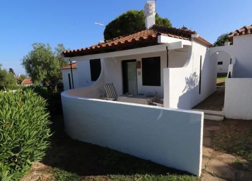 a small white house with a porch and avisor at Villa Pedras d'el Rei - 1 room 4 people in Santa Luzia