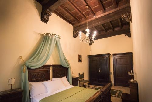 a bedroom with a bed with a green canopy at All'ombra della Torre only Rooms in Siena